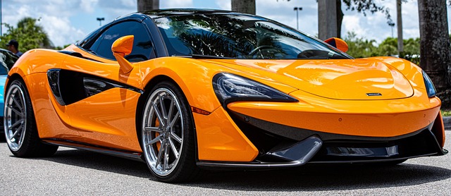 A photo of an orange McLaren supercar at three quarter view parked outside in the sun. NICE!